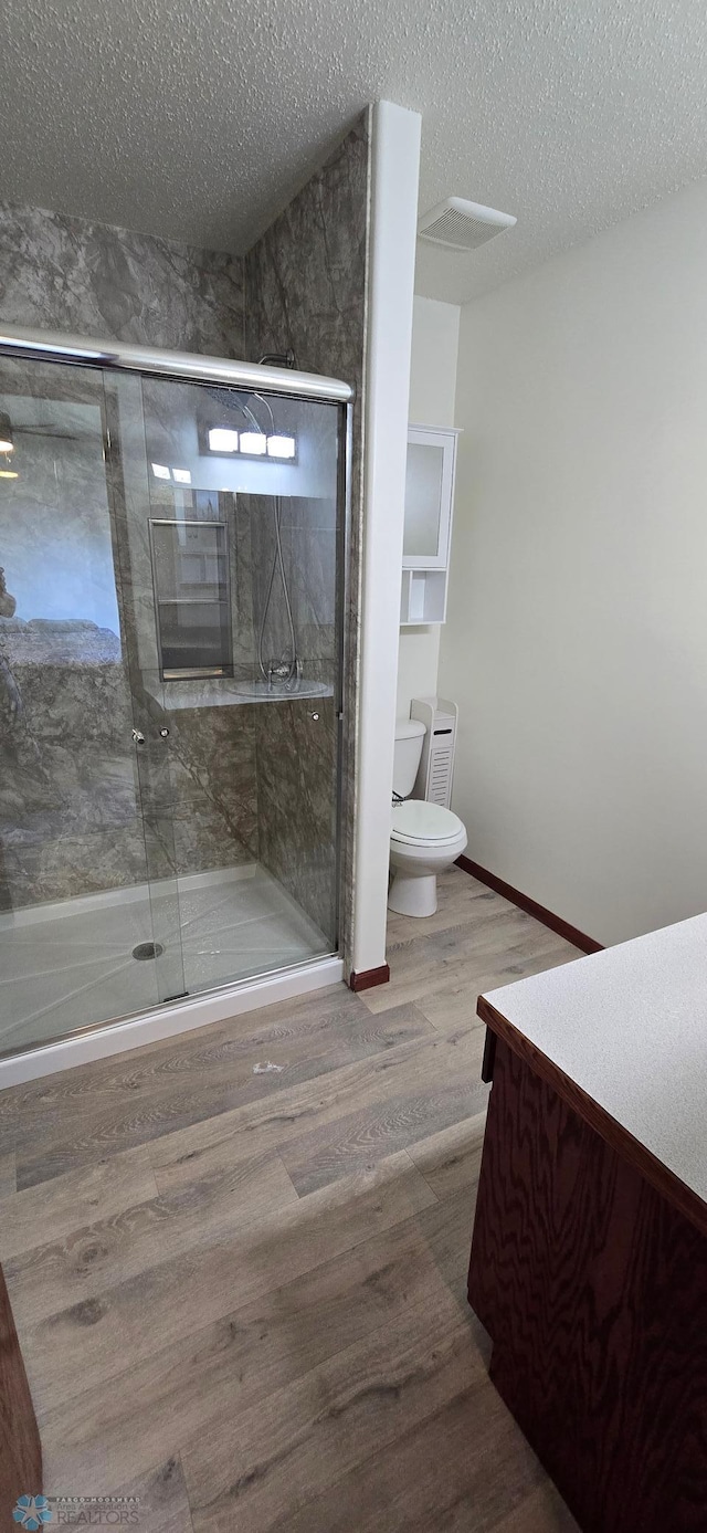 961 39 1/2 Ave W, West Fargo, ND 58078 - full bath with vanity, wood finished floors, a textured ceiling, and a shower stall