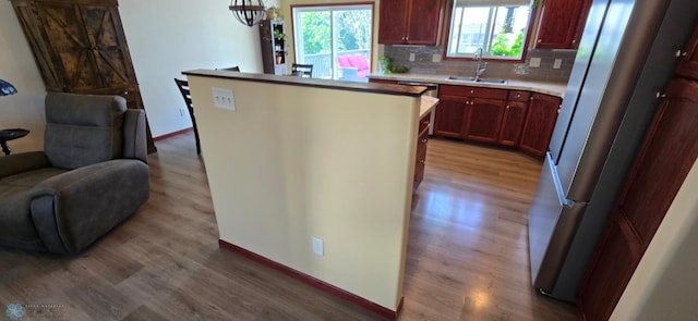 961 39 1/2 Ave W, West Fargo, ND 58078 - kitchen featuring wood finished floors, open floor plan, freestanding refrigerator, light countertops, and backsplash