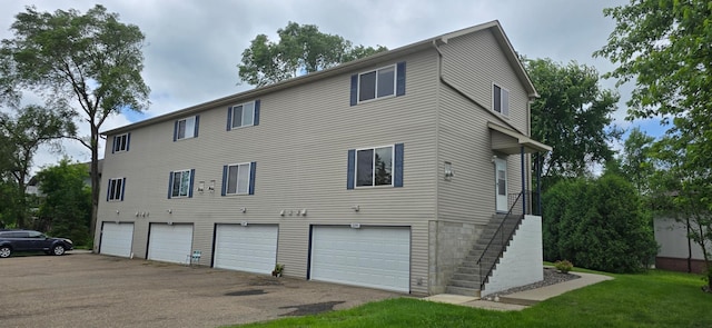 5293 Manchester Dr Unit 1, Maple Plain, MN 55359 - rear view of house featuring a garage, asphalt driveway, and stairs