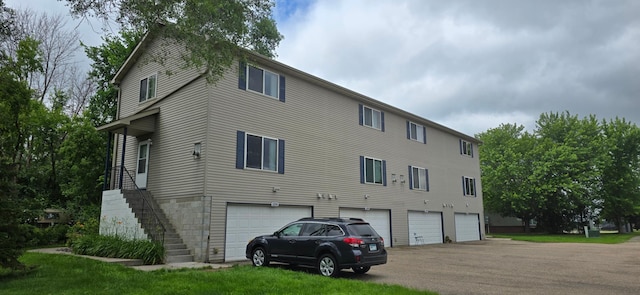 5293 Manchester Dr Unit 1, Maple Plain, MN 55359 - back of property featuring a garage, stairway, and asphalt driveway