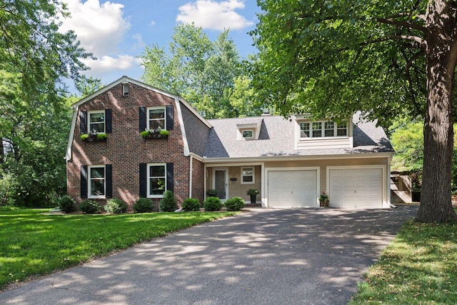 10301 Brunswick Cir, Bloomington, MN 55438 - dutch colonial with driveway, brick siding, a front yard, and roof with shingles