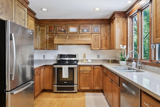 10301 Brunswick Cir, Bloomington, MN 55438 - kitchen with appliances with stainless steel finishes, extractor fan, light wood-type flooring, brown cabinets, and recessed lighting