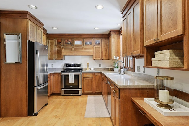 10301 Brunswick Cir, Bloomington, MN 55438 - kitchen with stainless steel appliances, custom range hood, brown cabinetry, light wood-style flooring, and recessed lighting