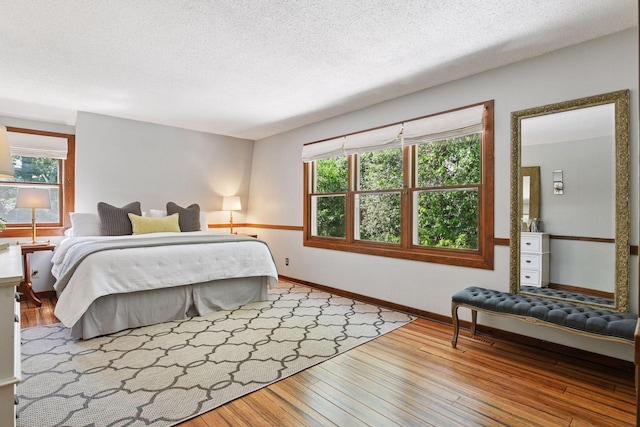 10301 Brunswick Cir, Bloomington, MN 55438 - bedroom with hardwood / wood-style floors, multiple windows, and a textured ceiling