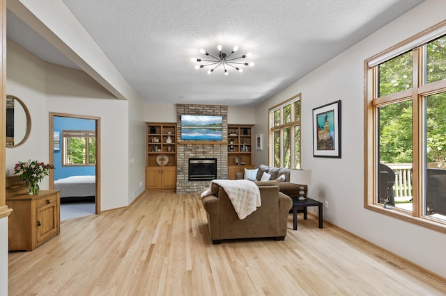 13756 Skyline Cir, Louisville Twp, MN 55379 - living room featuring light wood-type flooring, a brick fireplace, a chandelier, and a textured ceiling