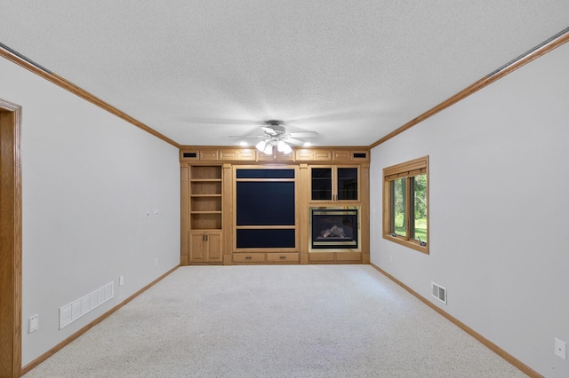13756 Skyline Cir, Louisville Twp, MN 55379 - unfurnished living room with a textured ceiling, ornamental molding, a ceiling fan, carpet floors, and built in features