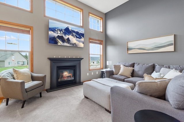 9769 Pinehurst Ct, Elko New Market, MN 55020 - carpeted living area with healthy amount of natural light, a high ceiling, and a glass covered fireplace