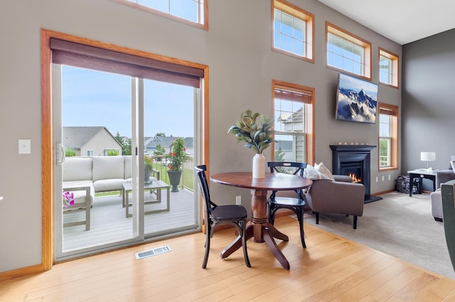 9769 Pinehurst Ct, Elko New Market, MN 55020 - dining area with plenty of natural light, a warm lit fireplace, a high ceiling, and wood finished floors