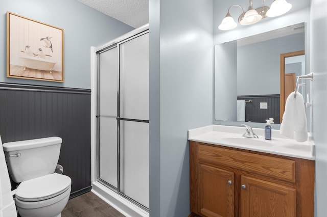 9769 Pinehurst Ct, Elko New Market, MN 55020 - bathroom featuring a wainscoted wall, a stall shower, vanity, wood finished floors, and a textured ceiling