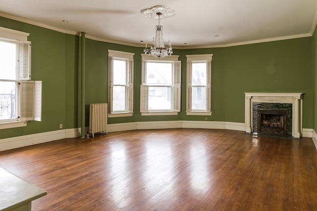 11 Summit Ct Unit 11, Saint Paul, MN 55102 - unfurnished living room featuring radiator, wood finished floors, a chandelier, healthy amount of natural light, and crown molding
