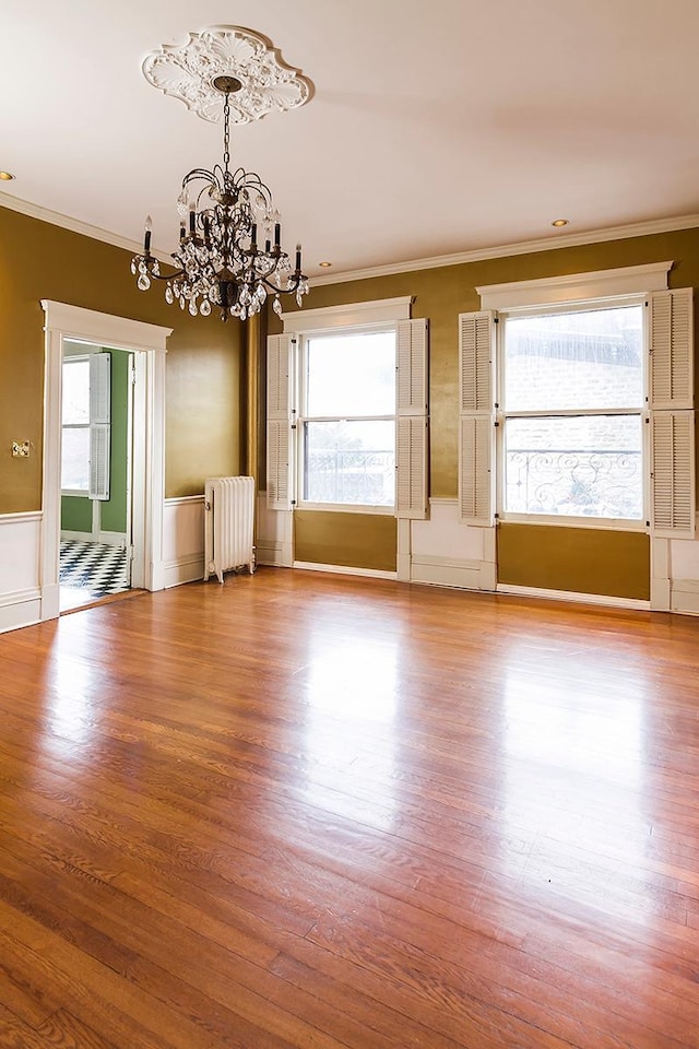 11 Summit Ct Unit 11, Saint Paul, MN 55102 - spare room with radiator heating unit, a chandelier, ornamental molding, wood finished floors, and healthy amount of natural light