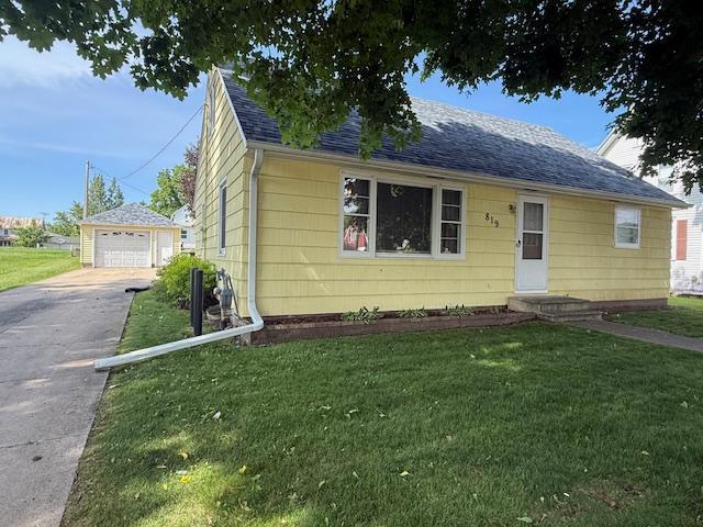 819 Washington St E, Caledonia, MN 55921 - bungalow-style home with driveway, a front lawn, and an outbuilding