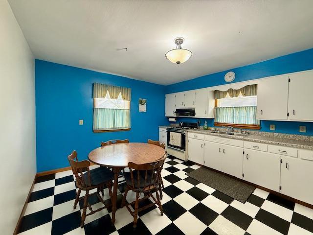 819 Washington St E, Caledonia, MN 55921 - kitchen with range with gas cooktop, light floors, plenty of natural light, and white cabinets