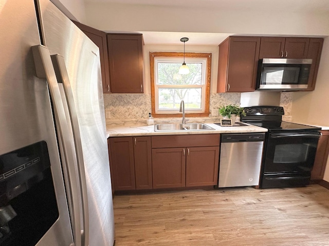 434 Rose Ave E, Saint Paul, MN 55130 - kitchen with appliances with stainless steel finishes, light wood finished floors, light countertops, decorative backsplash, and decorative light fixtures