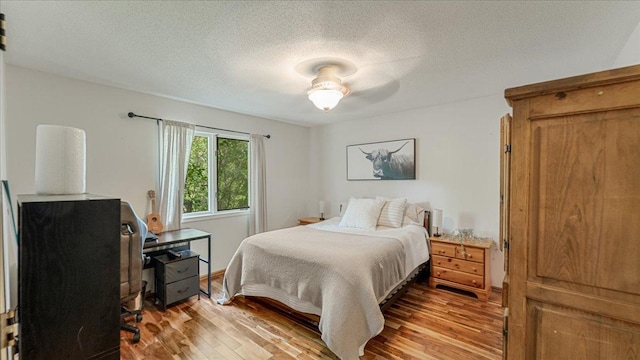 539 Deer Ridge Ln S, Maplewood, MN 55119 - bedroom with wood finished floors, a desk, and a textured ceiling