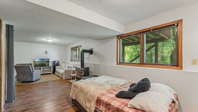 539 Deer Ridge Ln S, Maplewood, MN 55119 - bedroom with a wood stove, wood finished floors, and a textured ceiling