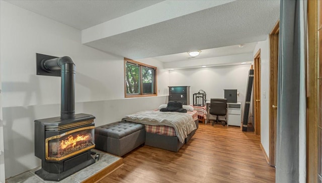 539 Deer Ridge Ln S, Maplewood, MN 55119 - bedroom featuring a wood stove, wood finished floors, and a textured ceiling