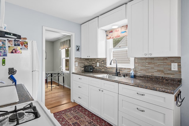 6916 Russell Ave S, Richfield, MN 55423 - kitchen with freestanding refrigerator, plenty of natural light, tasteful backsplash, and white cabinetry