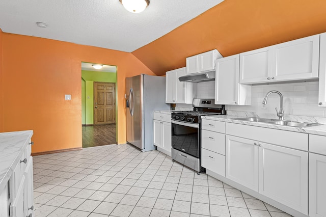 2414 3rd St NE, Minneapolis, MN 55418 - kitchen with appliances with stainless steel finishes, under cabinet range hood, decorative backsplash, white cabinets, and lofted ceiling