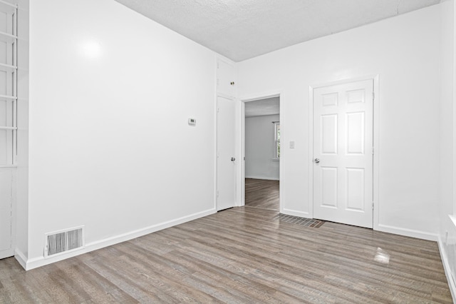 2414 3rd St NE, Minneapolis, MN 55418 - unfurnished room featuring wood finished floors and a textured ceiling