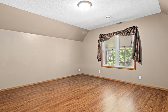 2414 3rd St NE, Minneapolis, MN 55418 - bonus room with lofted ceiling, wood finished floors, and a textured ceiling