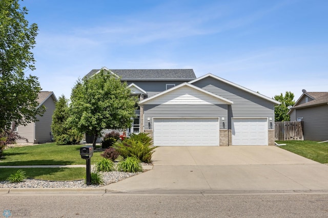 122 15th Ave E, Fargo, ND 58078 - view of front of house with an attached garage, driveway, and brick siding