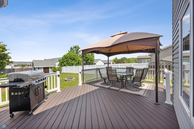 122 15th Ave E, Fargo, ND 58078 - wooden terrace featuring a gazebo, outdoor dining area, a grill, a fenced backyard, and a shed