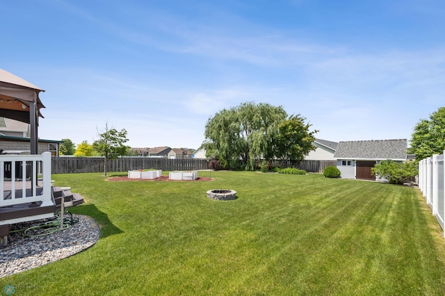 122 15th Ave E, Fargo, ND 58078 - fenced backyard featuring an outdoor fire pit and an outdoor structure