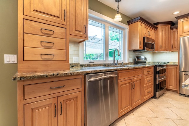 1430 Hoot Lake Dr, Fergus Falls, MN 56537 - kitchen featuring appliances with stainless steel finishes, backsplash, light tile patterned floors, pendant lighting, and dark stone countertops