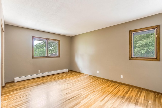 6108 Birchwood Rd, Woodbury, MN 55125 - unfurnished room with a baseboard radiator and light wood-type flooring