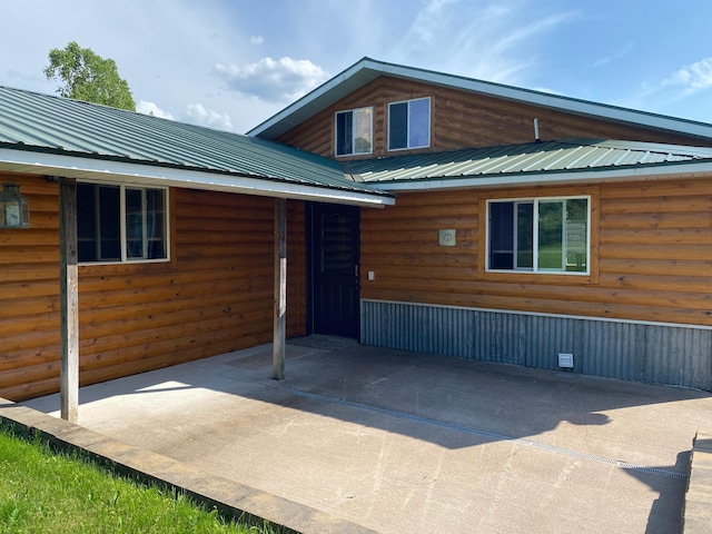 3653 Front St, Barnum, MN 55707 - view of front of home with faux log siding, a patio, and a metal roof