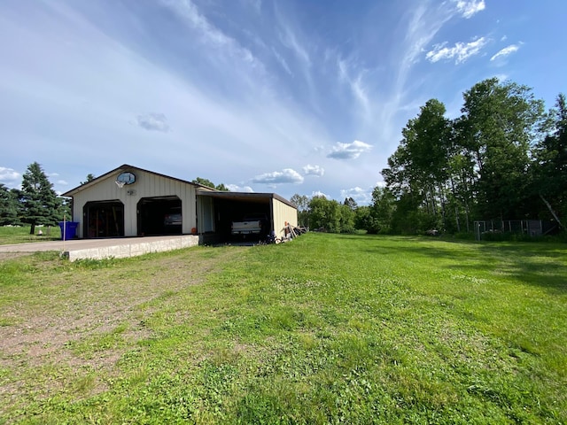 3653 Front St, Barnum, MN 55707 - view of grassy yard with a detached garage, an outdoor structure, an outbuilding, and driveway