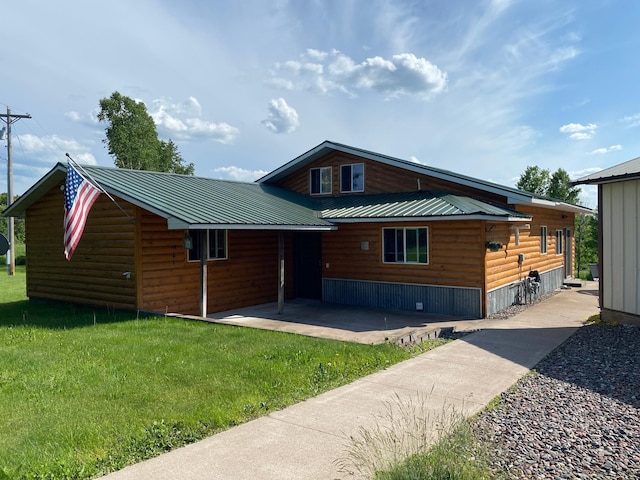3653 Front St, Barnum, MN 55707 - rear view of house featuring log veneer siding, a patio area, a yard, and a metal roof