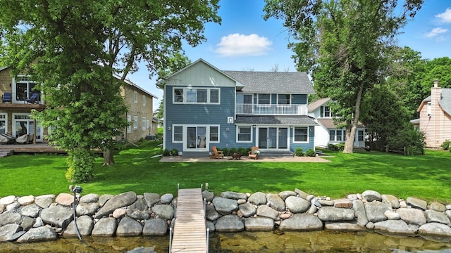 5459 Bartlett Blvd, Mound, MN 55364 - rear view of property with a lawn, a shingled roof, a balcony, entry steps, and a water view