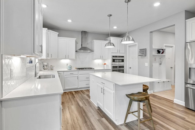 6439 Alvina Ct, Inver Grove Heights, MN 55077 - kitchen with wall chimney exhaust hood, appliances with stainless steel finishes, light wood-style flooring, a kitchen breakfast bar, and backsplash