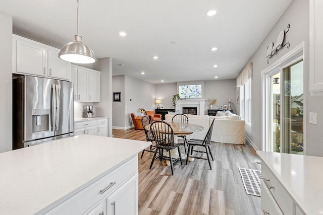 6439 Alvina Ct, Inver Grove Heights, MN 55077 - kitchen featuring stainless steel fridge, light countertops, recessed lighting, a glass covered fireplace, and light wood finished floors