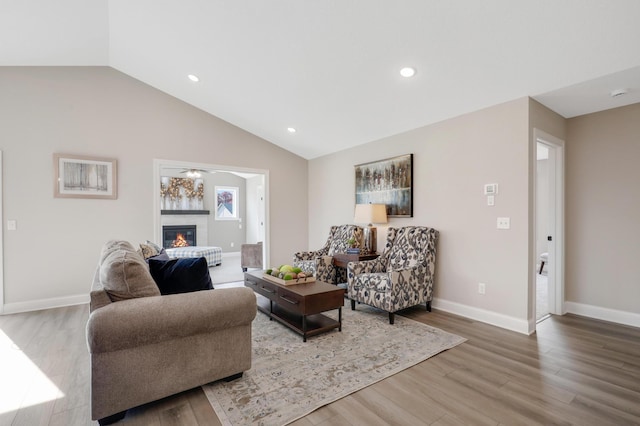 17785 Hoover St NW, Elk River, MN 55330 - living room featuring vaulted ceiling, a glass covered fireplace, wood finished floors, and recessed lighting