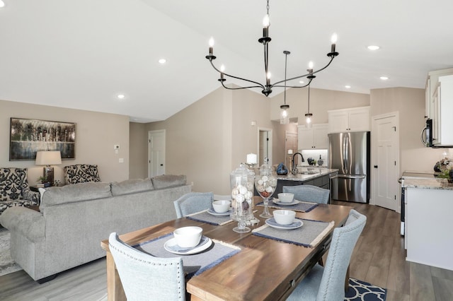 17785 Hoover St NW, Elk River, MN 55330 - dining area featuring vaulted ceiling, wood finished floors, recessed lighting, and a chandelier