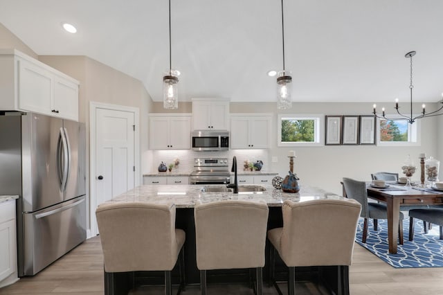 17785 Hoover St NW, Elk River, MN 55330 - kitchen with stainless steel appliances, a chandelier, light wood-type flooring, backsplash, and recessed lighting