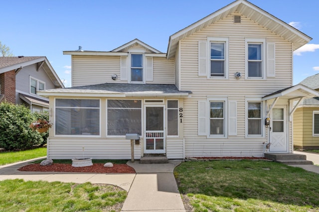 821 5th St, Winona, MN 55987 - view of front of property with a sunroom, a front yard, a shingled roof, and entry steps