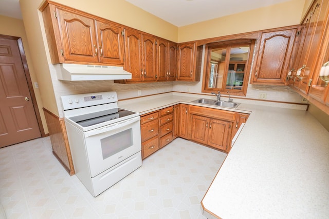 2303 Parkview Rd NE, Alexandria, MN 56308 - kitchen with white electric stove, under cabinet range hood, brown cabinetry, light countertops, and light flooring