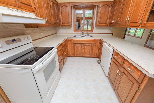 2303 Parkview Rd NE, Alexandria, MN 56308 - kitchen featuring white appliances, under cabinet range hood, brown cabinetry, and healthy amount of natural light