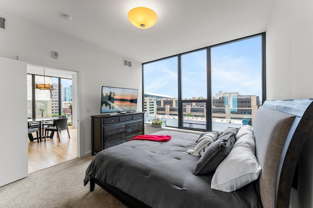 740 Portland Ave Unit 801, Minneapolis, MN 55415 - bedroom featuring light carpet, expansive windows, and a chandelier