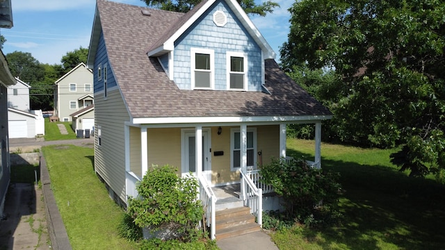 2931 Lyndale Ave N, Minneapolis, MN 55411 - view of front facade with covered porch, a shingled roof, and a front lawn