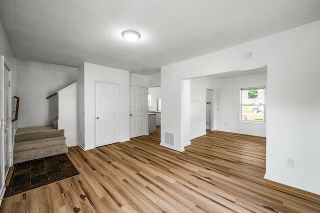 2931 Lyndale Ave N, Minneapolis, MN 55411 - unfurnished living room with wood finished floors, a textured ceiling, and stairway
