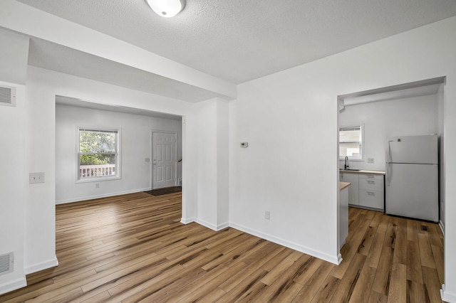 2931 Lyndale Ave N, Minneapolis, MN 55411 - empty room featuring wood finished floors, healthy amount of natural light, and a textured ceiling