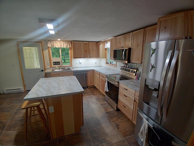 1959 79th St, Georgetown Twp, WI 54853 - kitchen featuring stainless steel appliances, a baseboard heating unit, a kitchen island, light countertops, and a breakfast bar area