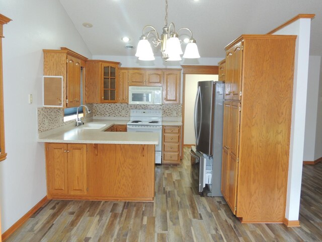38 Glenview Loop, Saint Cloud, MN 56303 - kitchen featuring white appliances, a peninsula, light wood finished floors, backsplash, and vaulted ceiling