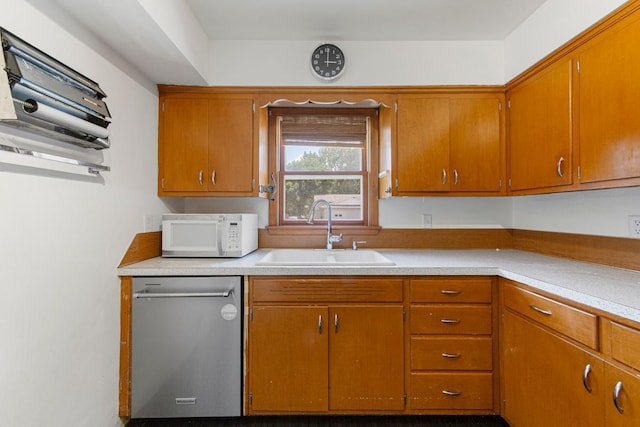 713 Sherman St, North Mankato, MN 56003 - kitchen with white microwave, stainless steel dishwasher, light countertops, and brown cabinetry