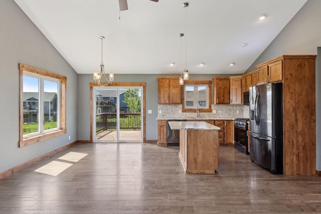 1664 Otter Way, New Richmond, WI 54017 - kitchen featuring stainless steel appliances, vaulted ceiling, brown cabinets, dark wood-type flooring, and decorative backsplash